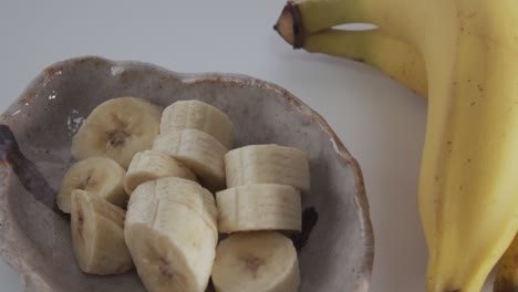 pan right sliced banana on plate and a bunch of bananas.