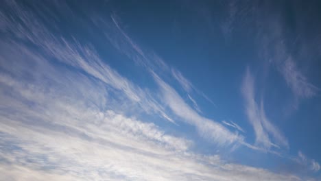 slowly moving white altostratus clouds over a blue sky