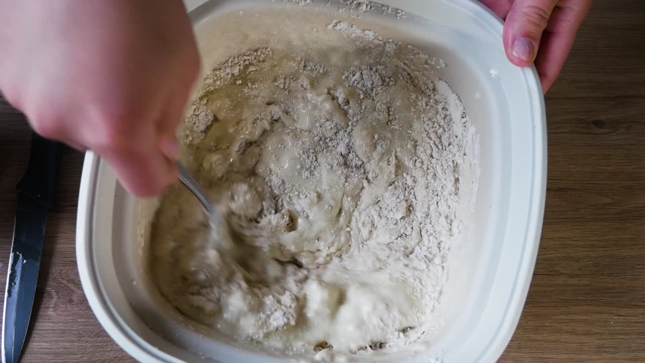 Female hands mixing batter for american pancakes in close up homemade shot