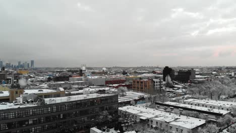 a cloudy nyc evening at sundown immediately after a snow storm is seen as the footage zooms over rooftops exploring the cityscape covered in white