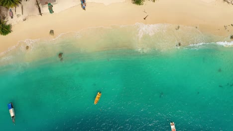 Aerial-view-of-boats-in-turquoise-water-on-beach-at-Asu-Island,-North-Sumatra,-Indonesia