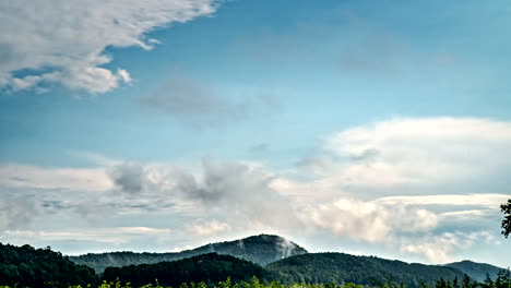 Timelapse-of-different-layers-of-clouds-moving-fast-and-slowly-above-european-wooded-hills-4K