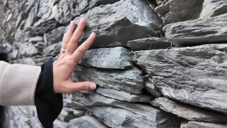 hand touching a stone wall