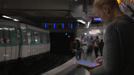 Frau-Benutzt-Pad-Auf-U-Bahn-Bahnsteig