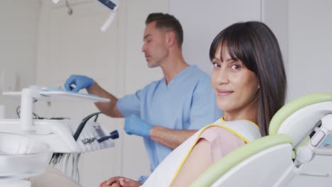 portrait of smiling female patient with caucasian male dentist at modern dental clinic