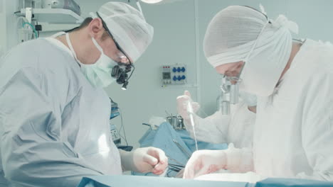 scrub nurse pours medical liquid into cavity. assistant keeps surgical area clean and clear of blood during coronary artery bypass graft surgery in clinic