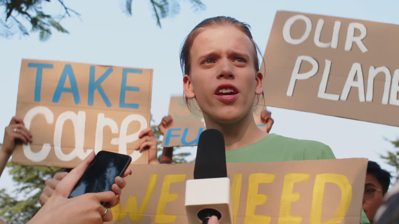 Caucasian Activist Answering Questions of Journalists during Protest