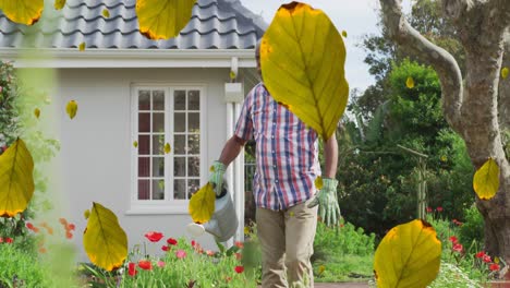 multiple leaves icon falling against african american senior man watering plants in the garden