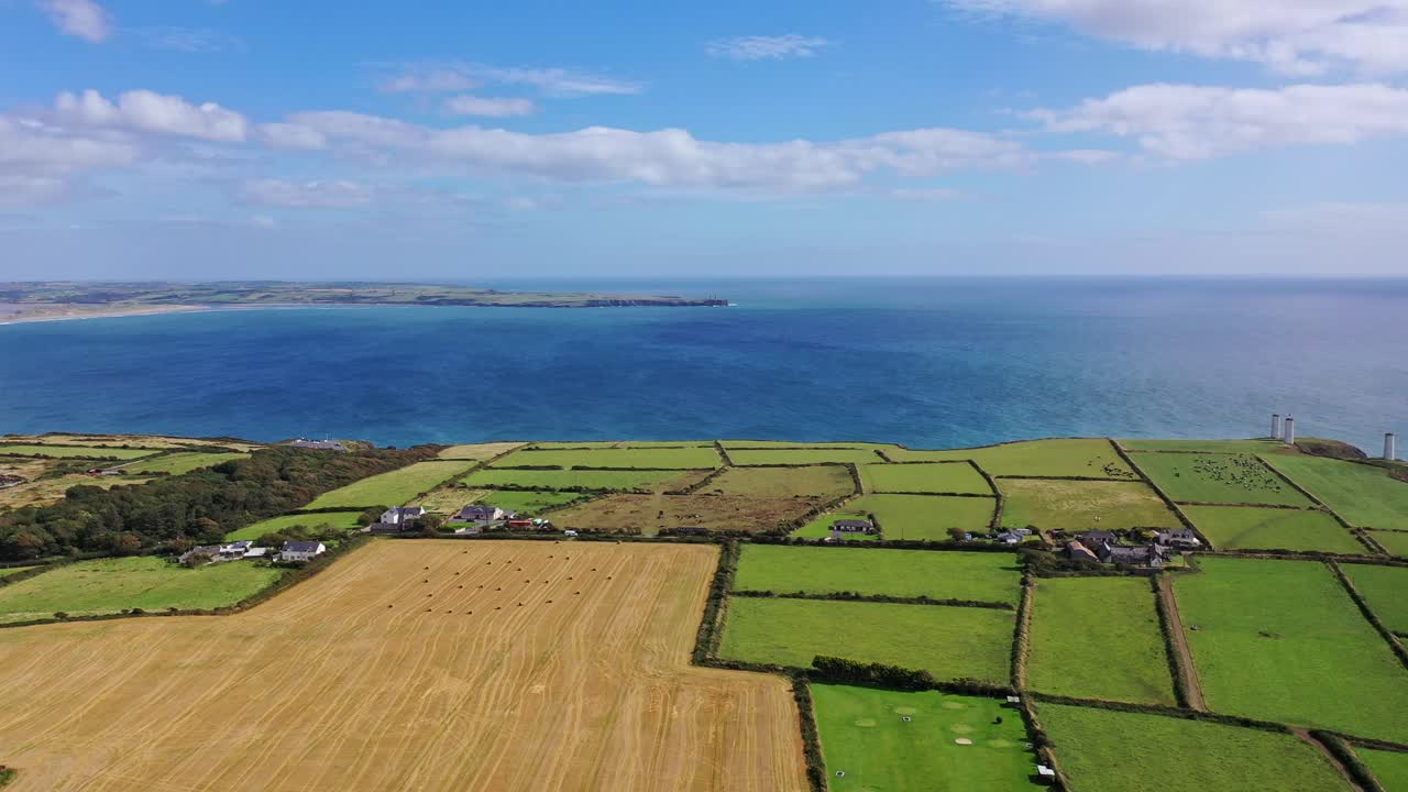 아일랜드 남쪽 해안의 공중 파노라마 뷰, 농경지, 주택단지 및 바위 해안선을 포함하여