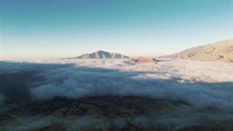 vista aérea panorámica de un amanecer sobre el tafí del valle, con una gigantesca nube baja cubriendo el valle