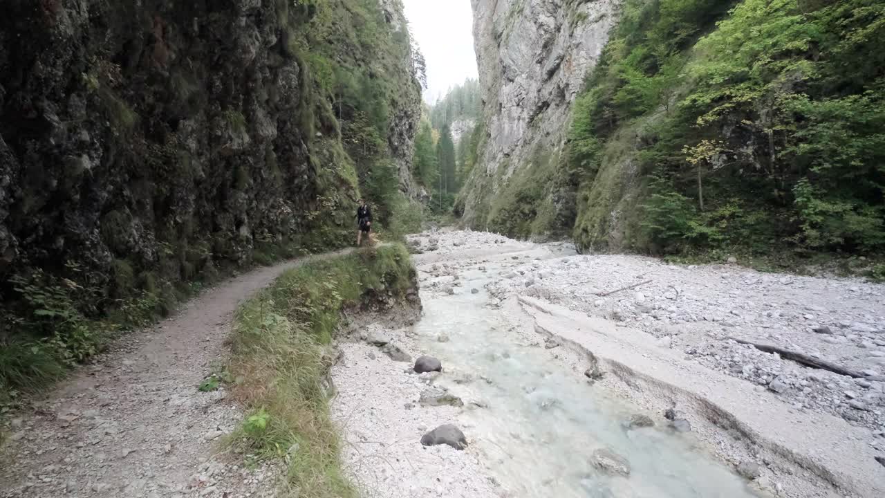 un hombre explorando la cascada martuljek durante el día en gozd martljek en eslovenia y el parque nacional triglav