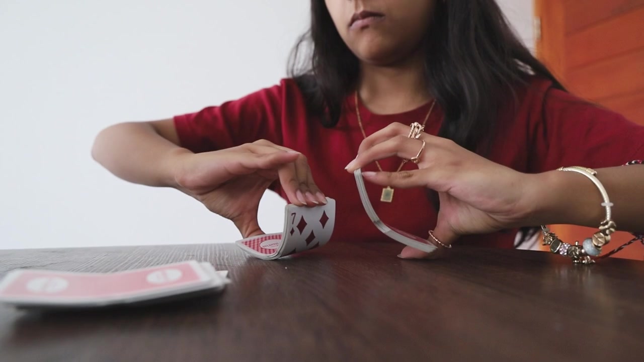Primo piano di donna che mescola un mazzo di carte da gioco