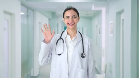 una doctora india feliz saludando a la cámara