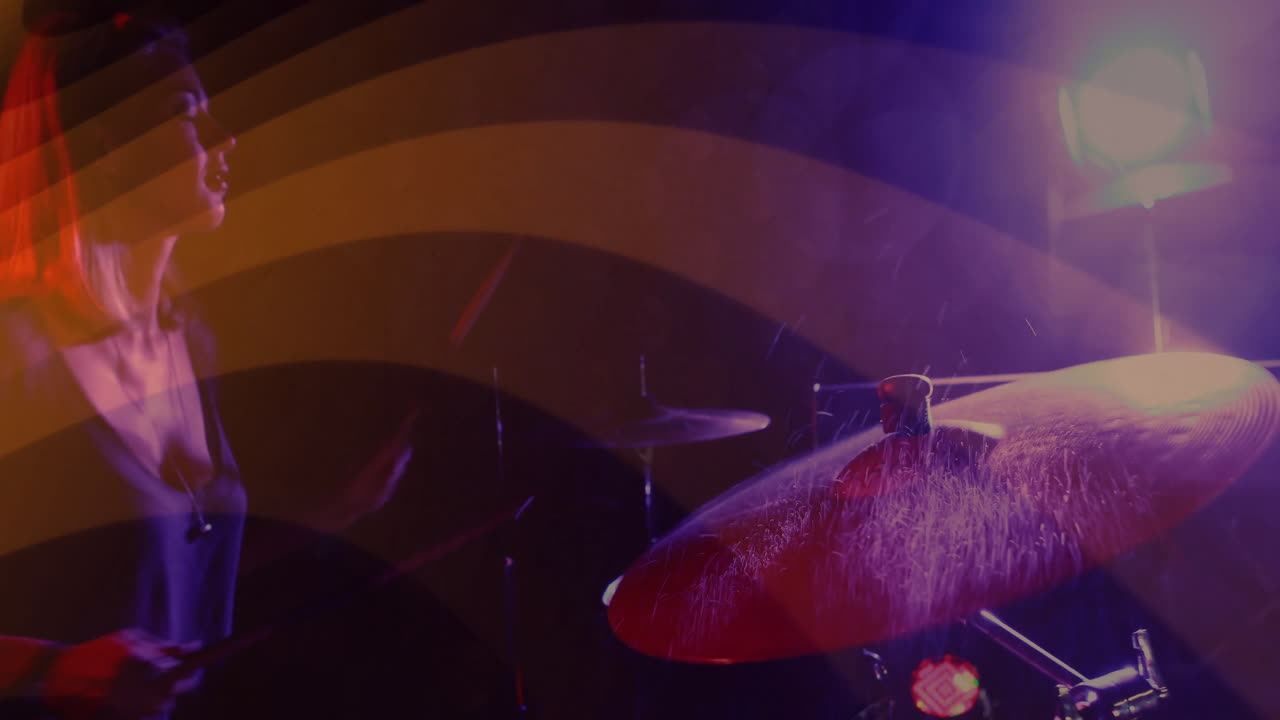 female drummer hitting cymbal on dim music stage, showing animated sound waves and droplet overlay