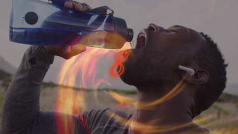 man pouring water from water bottle while fitness training outdoors with orange flame overlay