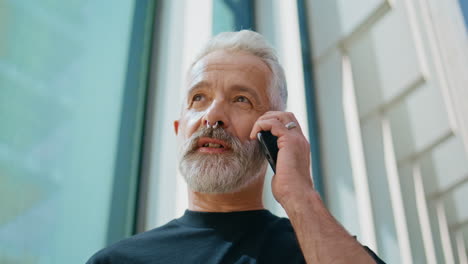 un hombre de negocios está hablando con su teléfono inteligente en la calle.
