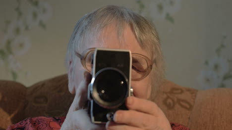 elderly woman with retro camera at home