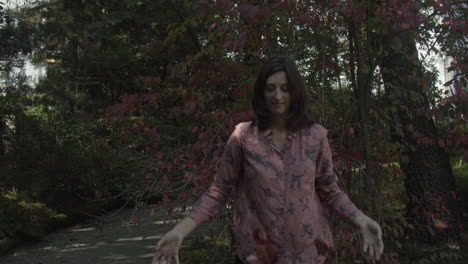 young woman tossing up leaves in autumnn, slow motion, wide shot