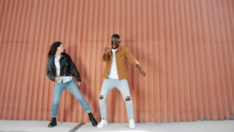 couple dancing in front of an orange wall
