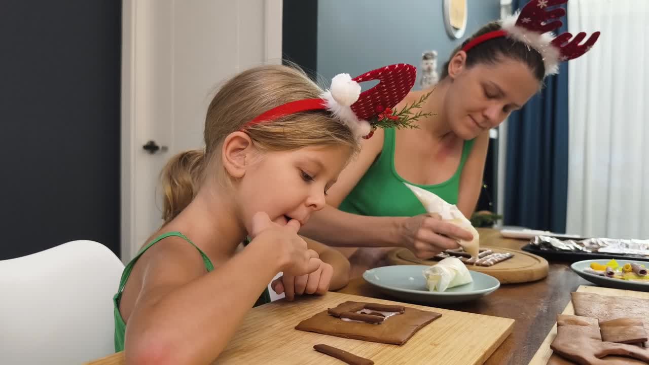 어머니 와 딸 이 생강  집 을 장식 하고 있다