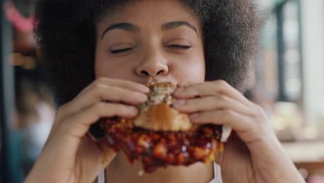 beautiful woman with afro eating burger in restaurant enjoying delicious juicy hamburger mouth watering meal african american female having lunch 4k