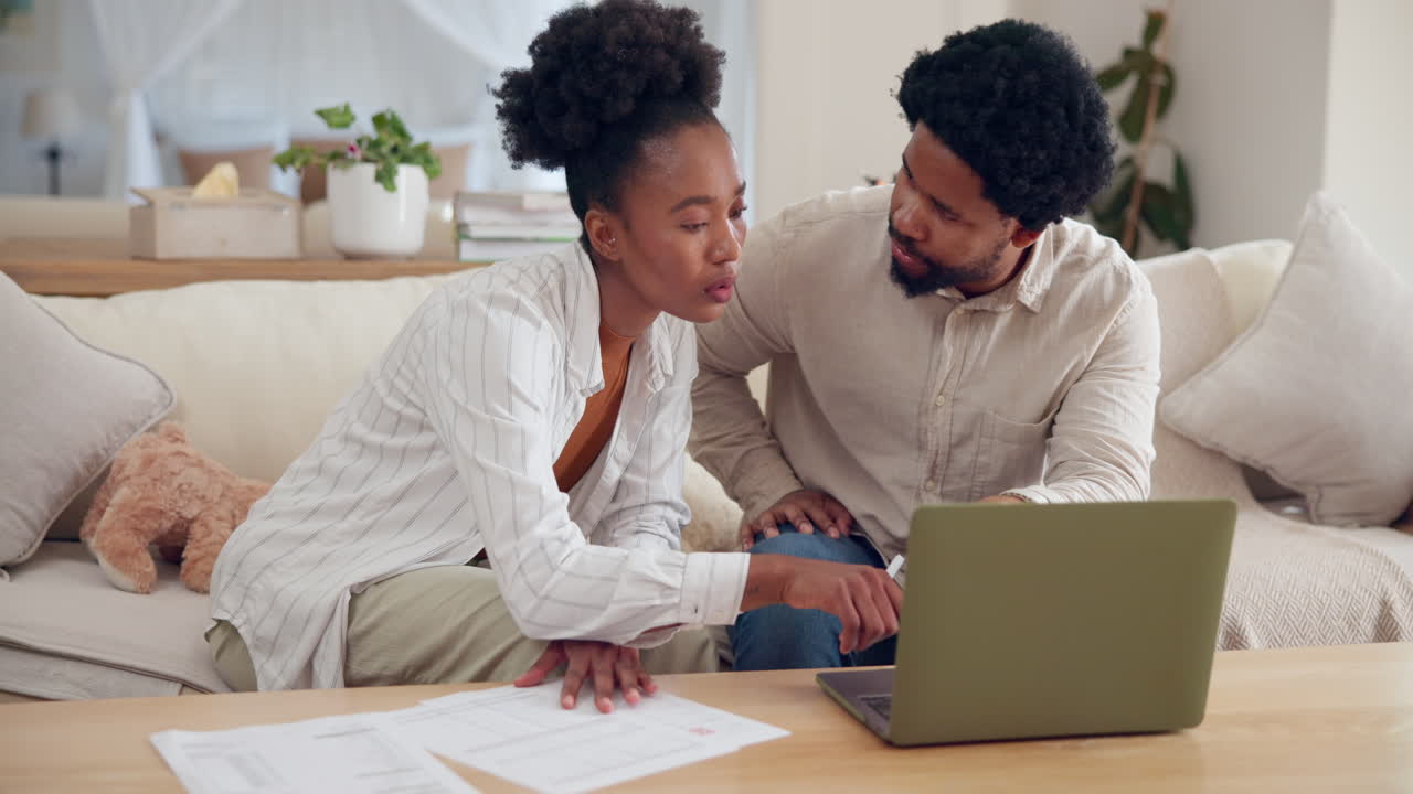Couple planning finances at home with laptop