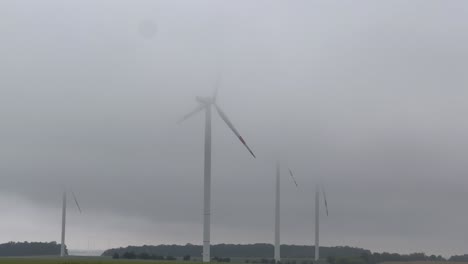 wind turbines shrouded in fog