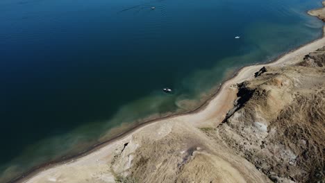 Flying-Over-Beautiful-Blue-Lake-in-Prairies-in-Alberta,-Canada-in-Summertime