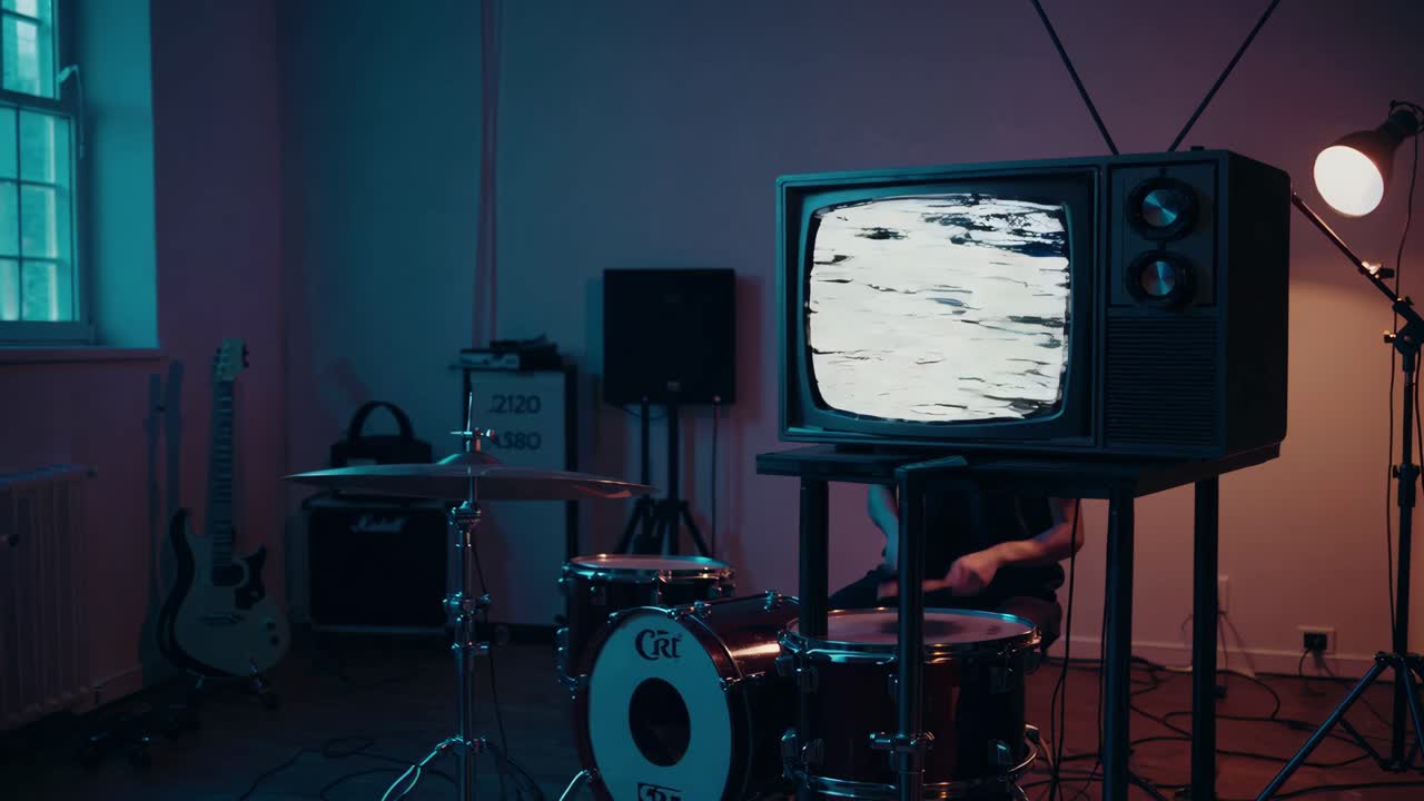 빈티지 tv와 함께 방에서 연주하는 드럼 연주자