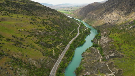 green valley with turquoise river and highway, new zealand