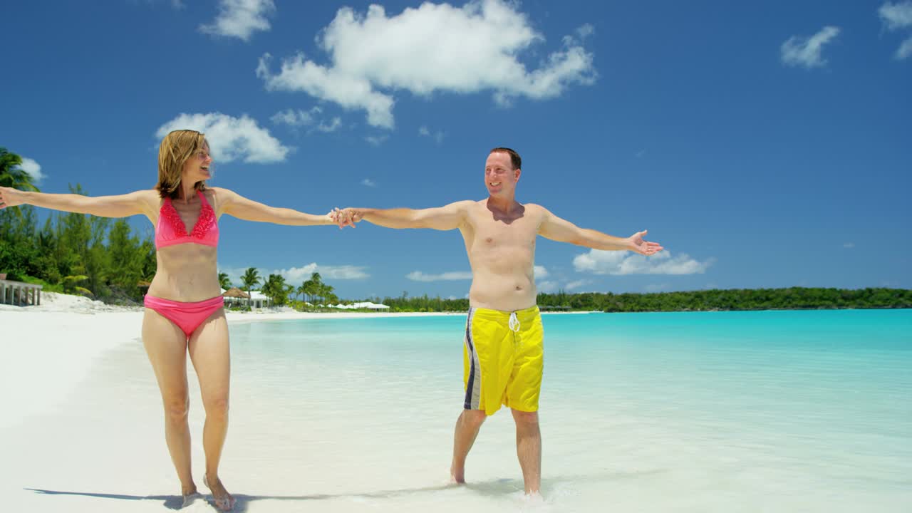Caucasian couple in swimwear at tropical beach resort