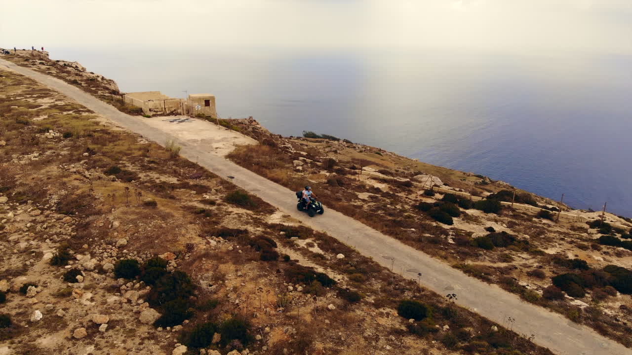 pareja conduciendo atv a lo largo de la hermosa carretera costera