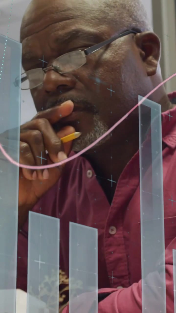 Vertical video: Chart overlay appearing, man leaning writing pausing studying figures making choice
