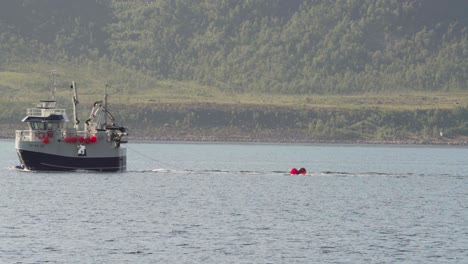 fishing boat cruising in the island of husoya in nordland, norway