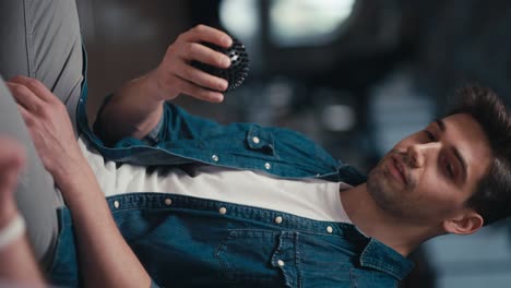 vertical video of a brunette man in a blue denim jacket passing a black ball to another group therapy participant. expressing your opinion and introducing yourself while passing the ball to each other