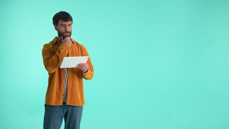 hombre barbudo pensativo trabajando en la tableta