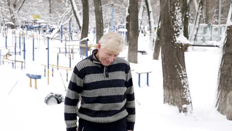 an elderly european man does a morning outdoor warm-up in the winter, exercise for a warm-up of the neck. healthy life concept. 60 fps