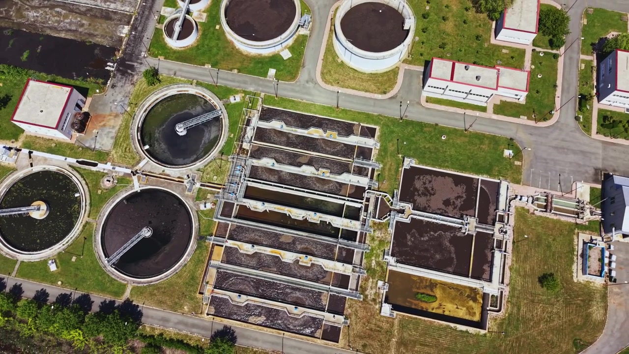 Detailed aerial imagery of wastewater treatment system components. Comprehensive drone imaging showcasing operational setup and safety features of sewage treatment plant
