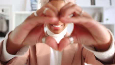happy african american woman smiling tenderly demonstrating heartshaped hands