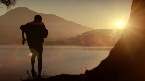 man running at sunrise by the lake