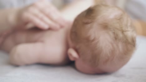 skilled pediatrician performs hypertonus infant massage