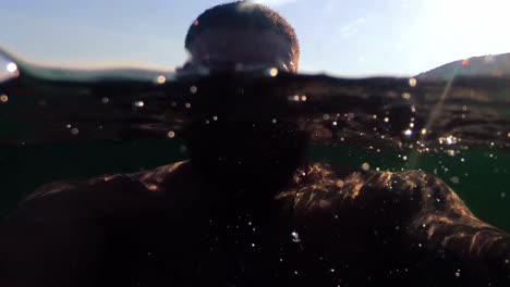 hombre disfrutando bañándose en el mar