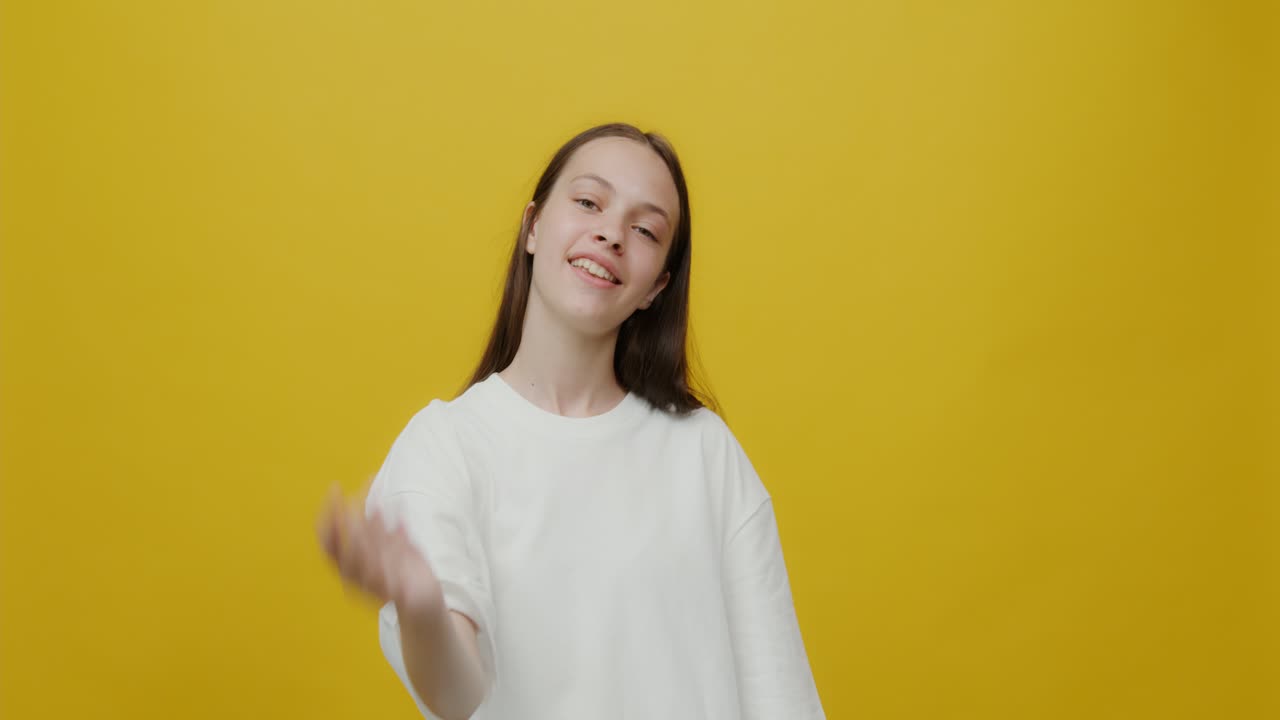 노란색 스튜디오에서 미소 짓는 십대 소녀