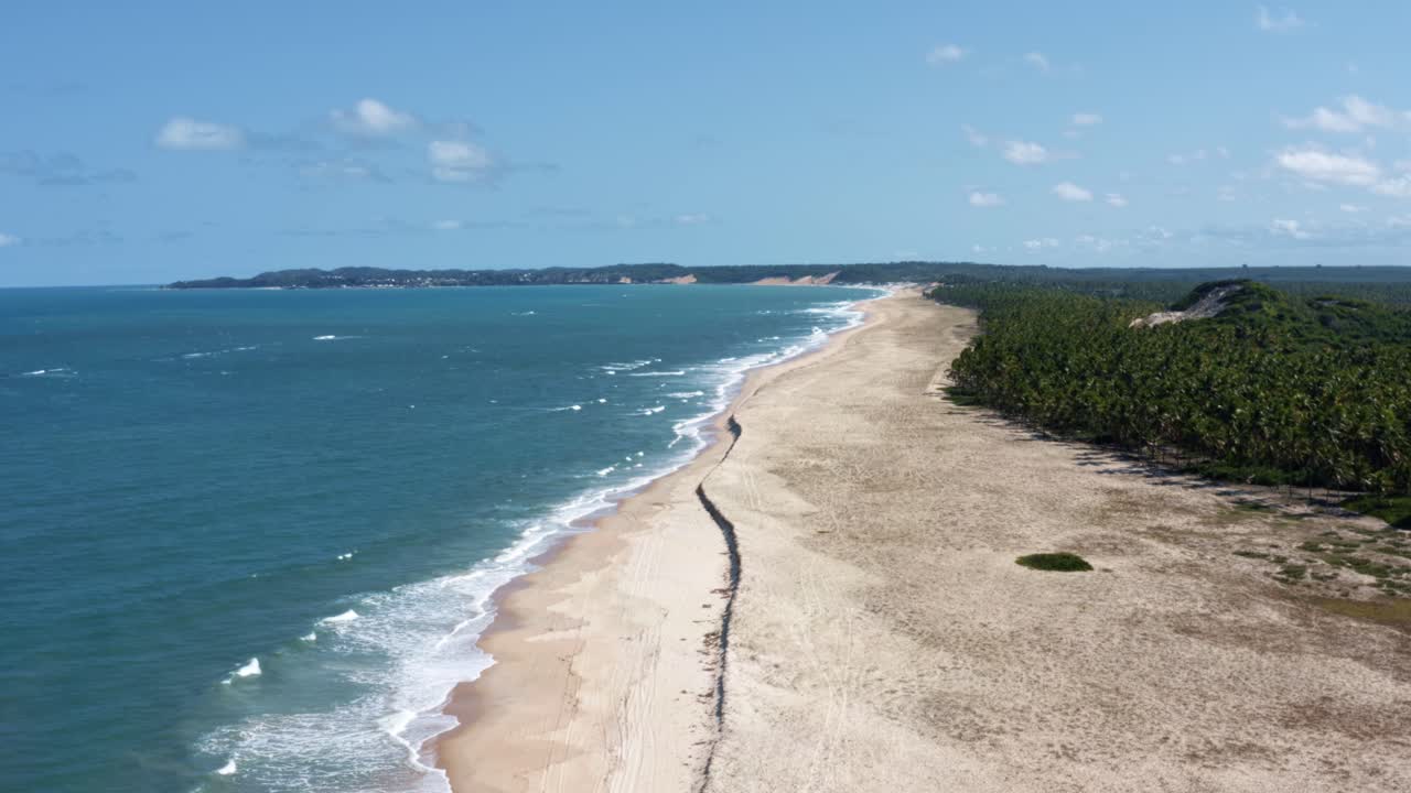 toma aérea de un paisaje amplio de drones de la costa tropical de río grande do norte, brasil con una playa blanca virgen, agua azul del océano y palmeras entre baia formosa y barra de cunha?
