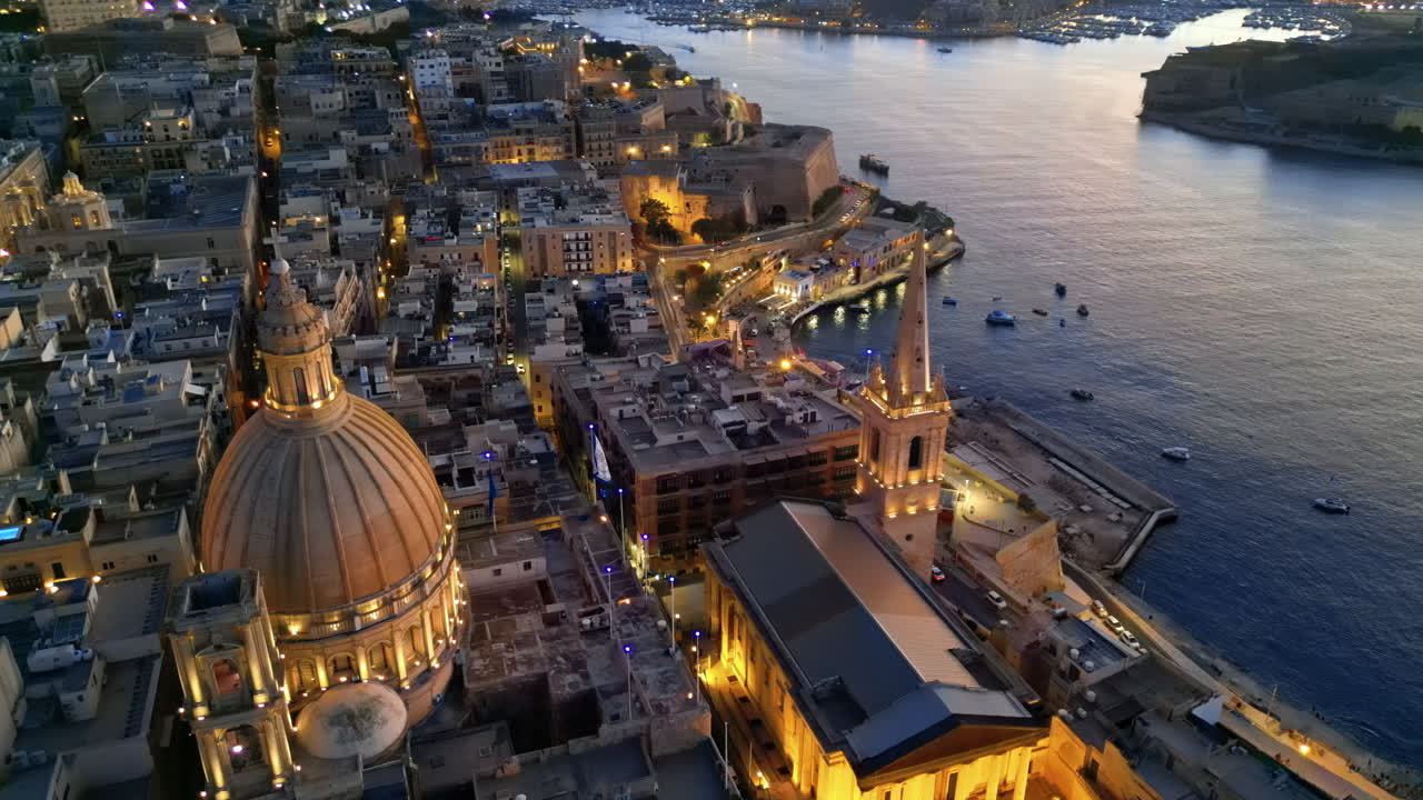 Aerial drone view of the walled city of Valletta, Malta, surrounded by the Mediterranean sea in the evening