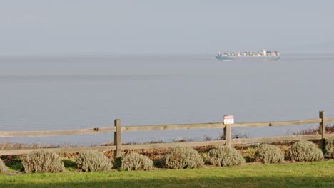 industrial container cargo ship sailing on the open sea on a sunny day in port angeles, washington, usa- wide shot