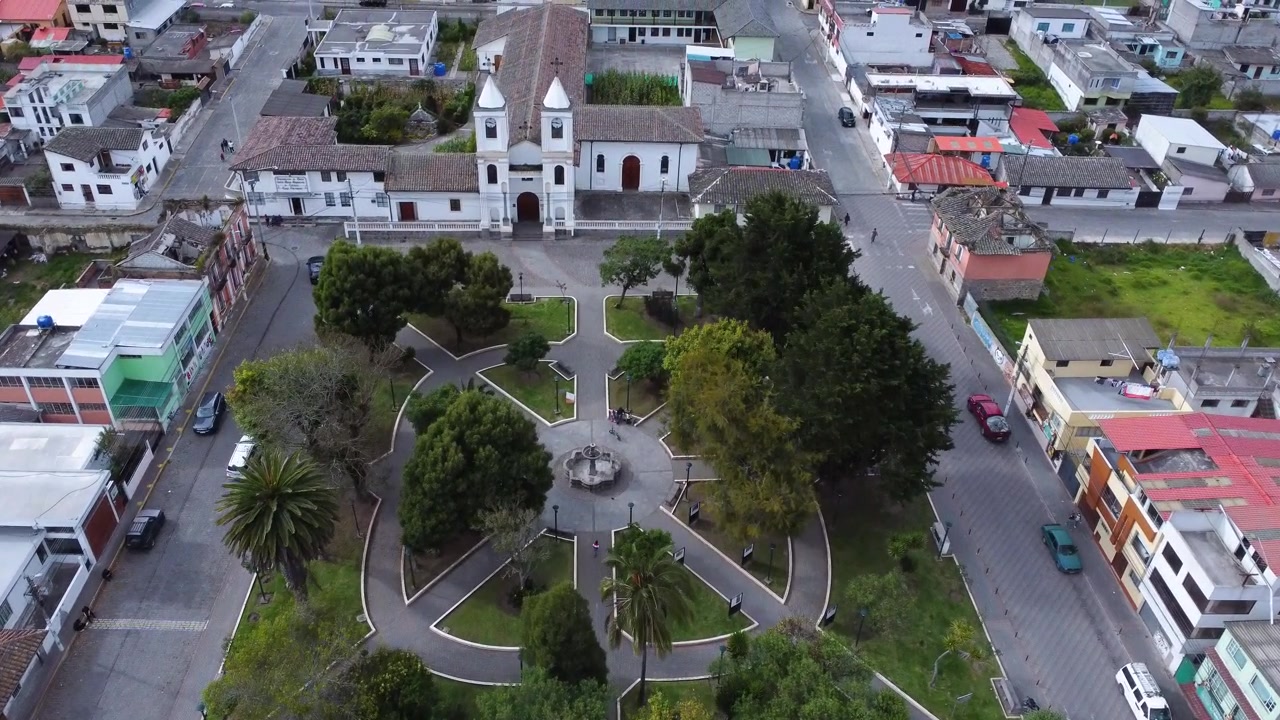 Drone che avanza sopra Calacali, sorvolando il monumento e la chiesa della Mitad del Mundo nel centro della città dell'Ecuador.