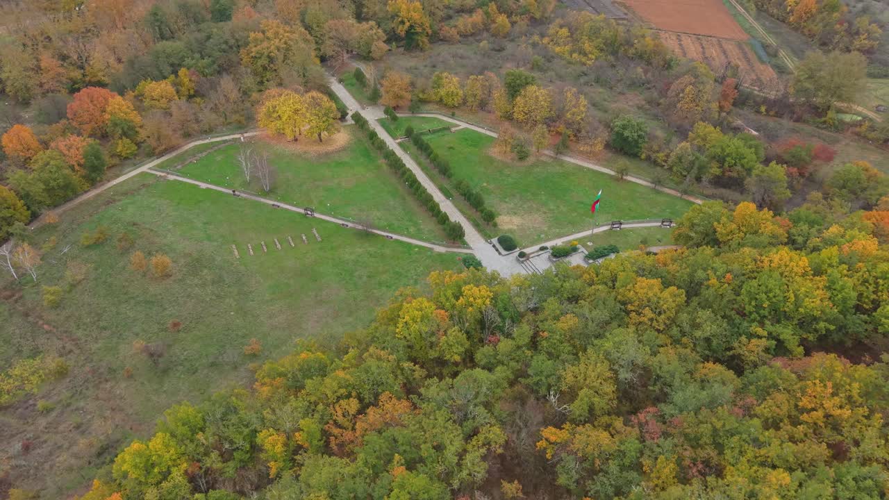 Aerial drone pullback reveals Samuil's Fortress in Bulgaria, gradually showcasing the surrounding hills, forests, and scenic natural landscape