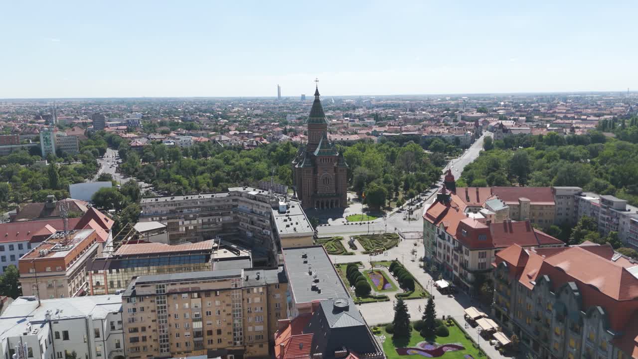 Drone orbiting over city structures, capturing the vast urban layout of Timisoara and the cathedral in the distance