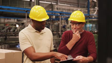 workers discussing over clipboard